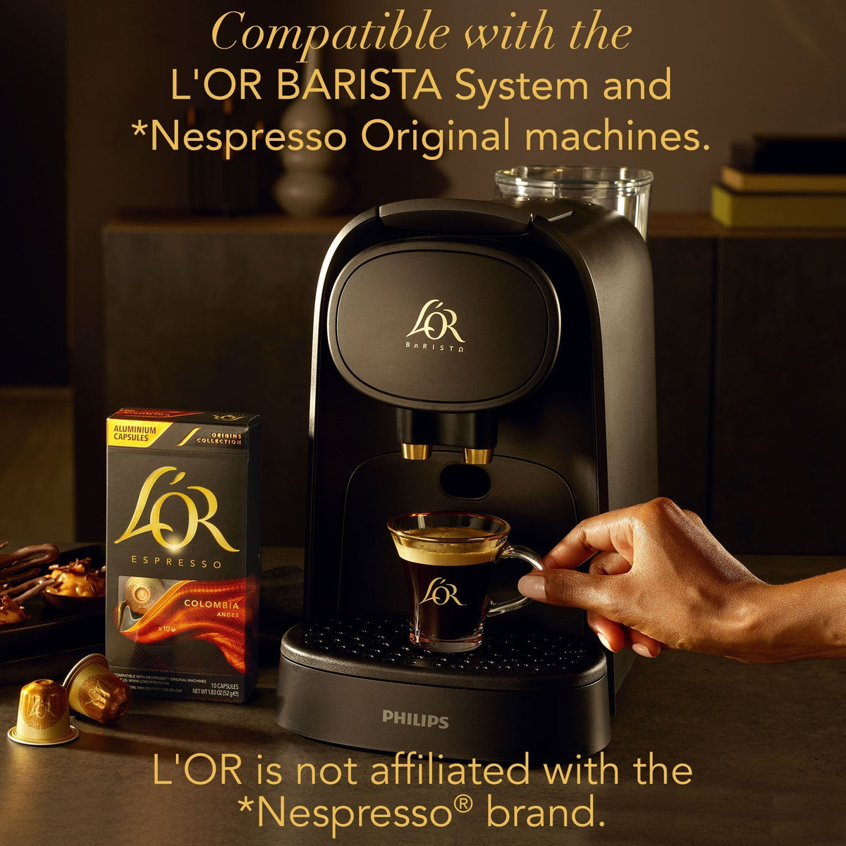 Coffee machine with a glass of coffee and L'OR coffee packaging on a wooden surface.